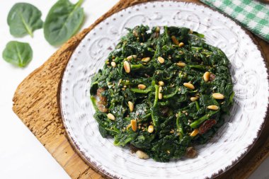 Kuru üzüm, çam fıstığı ve sarımsaklı bir tavada pişirilmiş ıspanak..