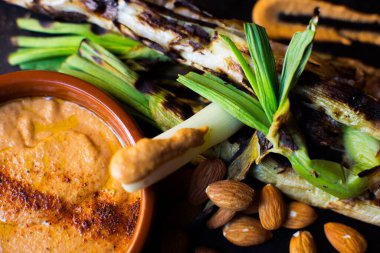 Romesco soslu Calsots. Calotlar, Kasım ve Nisan ayları arasında yetişen çeşitli taze soğanlardır..