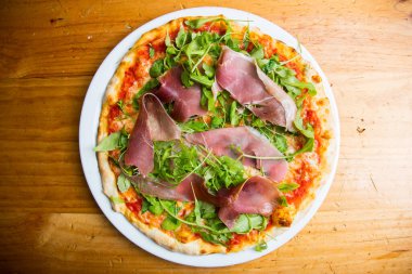 Serrano jambonlu pizza. Fırında sebze ve serrano jambonundan yapılmış Napoli pizzası. İtalyan vejetaryen tarifi.