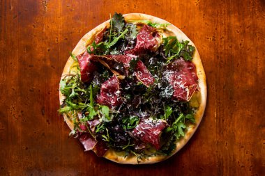 Pizzalı carpaccio. Domates soslu, peynirli ve biftekli Napoli pizzası. İtalyan tarifi.