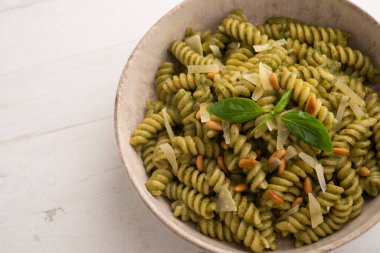 Pesto soslu makarna. Pesto, Liguria kökenli tipik bir sostur. Ana bileşeni fesleğen. Fesleğene ek olarak, çam fıstığı ve sarımsak da parmesan peyniri ve / veya koyun peyniri ve zeytinyağı ile tatlandırılmıştır..
