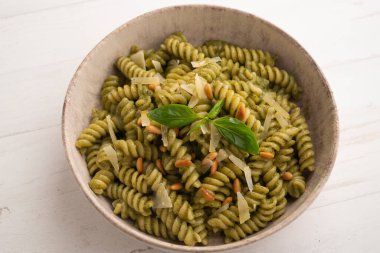 Pesto soslu makarna. Pesto, Liguria kökenli tipik bir sostur. Ana bileşeni fesleğen. Fesleğene ek olarak, çam fıstığı ve sarımsak da parmesan peyniri ve / veya koyun peyniri ve zeytinyağı ile tatlandırılmıştır..