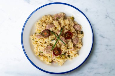 Sosisli risotto. Risotto, pilava yavaş yavaş et suyu ve belirli risotto tariflerine göre değişen diğer malzemelerle birlikte yapılan geleneksel bir İtalyan yemeğidir..