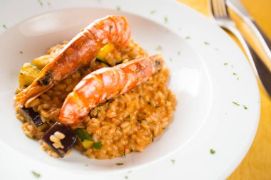 Karidesli risotto. Risotto, pilava yavaş yavaş et suyu ve belirli risotto tariflerine göre değişen diğer malzemelerle birlikte yapılan geleneksel bir İtalyan yemeğidir..