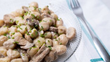 Mantarlı ve kremalı Gnocchis. Gnocchi veya gnocchi, İtalyan makarnasının bir türüdür. Patates, un ve ricotta peynirinden yapılmışlar..