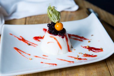 Panna cotta, İtalyan Piedmont bölgesinin tipik bir tatlısıdır, süt, krema, şeker ve jölelerden yapılır ve genellikle kırmızı meyve reçelleri ile süslenir..