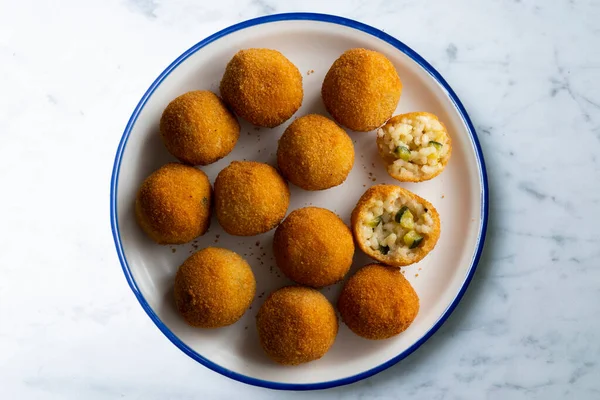 stock image Arancini are a specialty of Sicilian cuisine. They are deep-fried, breaded rice balls or cones 812 cm in diameter, usually filled with rag, peas and cheese, or diced ham and mozzarella.