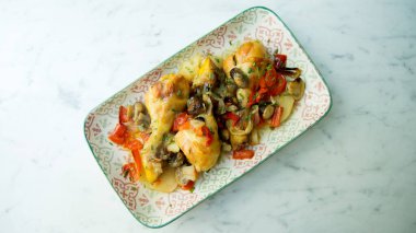 Pişmiş tavuk sebze ve patatesle pişirilir..