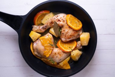 Baharatla marine edilmiş haşlanmış tavuk ve patates ile portakal sosu..