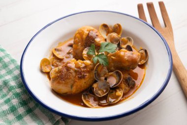 Deniz tarağı ve sebzeyle pişirilmiş tavuk butları..