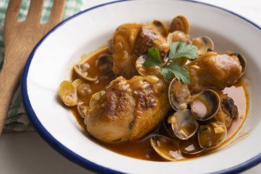 Deniz tarağı ve sebzeyle pişirilmiş tavuk butları..