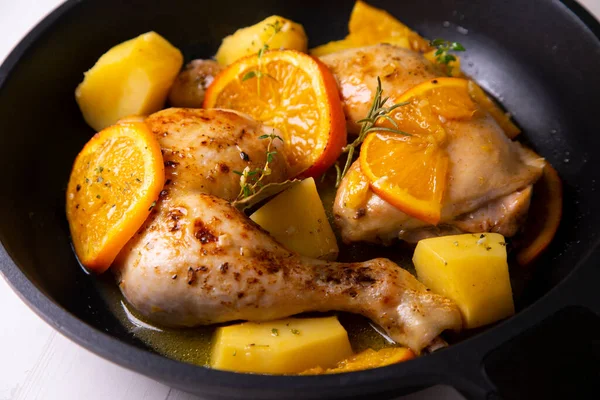 Braised chicken marinated with spices and orange sauce with potatoes.