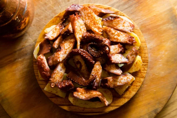 Galician octopus tapa. Sliced fresh octopus served on potatoes cooked with olive oil and red paprika. Traditional recipe in the region of Galicia in Spain.