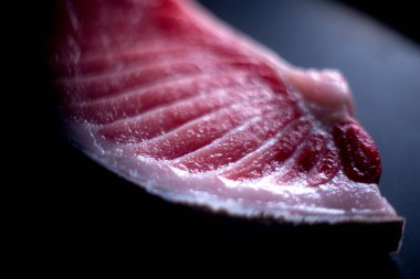 Kaliteli kırmızı toro balığı dilimi koyu arkaplanda.