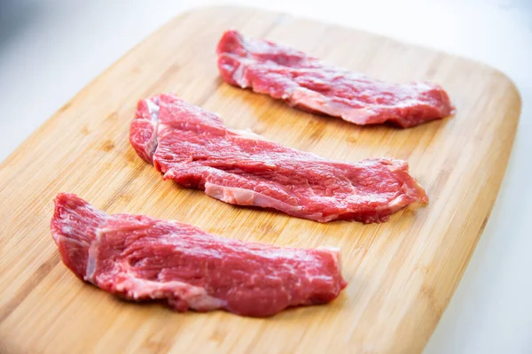 Premium steak beef on wood base on a white background.