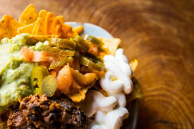 Guacamole soslu cips. Nachos Meksika kökenli bir yemektir, özel bir peynirle kaplanmış kızarmış mısır tortilla parçalarından oluşur..