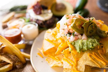 Guacamole soslu cips. Nachos Meksika kökenli bir yemektir, özel bir peynirle kaplanmış kızarmış mısır tortilla parçalarından oluşur..