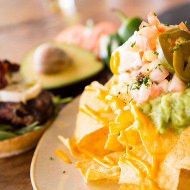 Guacamole soslu cips. Nachos Meksika kökenli bir yemektir, özel bir peynirle kaplanmış kızarmış mısır tortilla parçalarından oluşur..