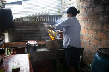 Cuipari, Peru; 1 Ekim 2022: Bir kadın bir tavuk koparıp Peru ormanında pişiriyor.