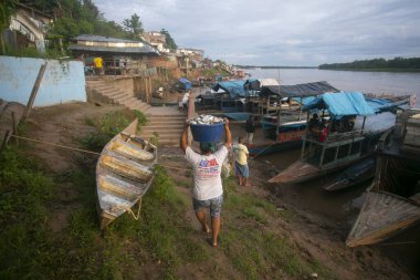Yurimaguas, Peru 1 Ekim 2022: Balıkçılar Peru ormanlarındaki Huallaga Nehri 'nde teknelerinden balık indiriyorlar.