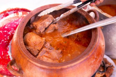 Adobo de Chancho are quipeo, yanında kilden bir tencerede pişirilmiş sebze ve baharatlarla marine edilmiş domuz eti tabağından oluşur.