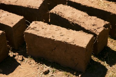 Elleriyle kerpiç tuğlalı ve çamurlu bir ev inşa eden bir adam. Peru 'daki Titicaca Gölü' nün Llachon bölgesi.