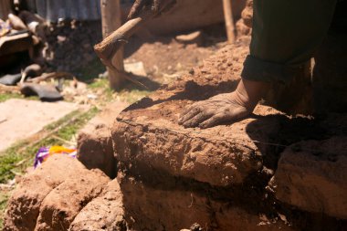 Elleriyle kerpiç tuğlalı ve çamurlu bir ev inşa eden bir adam. Peru 'daki Titicaca Gölü' nün Llachon bölgesi.