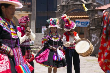 Taquile, Peru; 1 Ocak 2023: Peru 'nun Taquile adasında yaşayanlar, adanın ana meydanında bir etkinlikte dans edip müzik çalıyorlar..