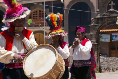 Taquile, Peru; 1 Ocak 2023: Peru 'nun Taquile adasında yaşayanlar, adanın ana meydanında bir etkinlikte dans edip müzik çalıyorlar..