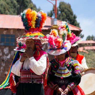 Taquile, Peru; 1 Ocak 2023: Peru 'nun Taquile adasında yaşayanlar, adanın ana meydanında bir etkinlikte dans edip müzik çalıyorlar..