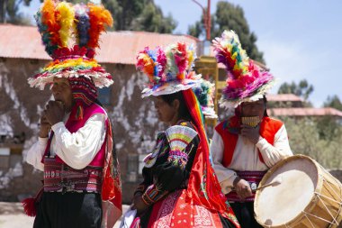 Taquile, Peru; 1 Ocak 2023: Peru 'nun Taquile adasında yaşayanlar, adanın ana meydanında bir etkinlikte dans edip müzik çalıyorlar..