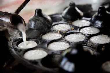 Hindistan cevizi Thai tatlısı hazırlayan kadın. Kanom krok lezzetli bir Tayland hindistan cevizi sütü tabanlı mini krep popüler sokak yemekleri..