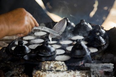 Hindistan cevizi Thai tatlısı hazırlayan kadın. Kanom krok lezzetli bir Tayland hindistan cevizi sütü tabanlı mini krep popüler sokak yemekleri..