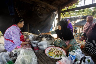 Sichon, Tayland; 1 Ocak 2023: Hindistan cevizi Thai tatlısı hazırlayan kadın. Kanom krok lezzetli bir Tayland hindistan cevizi sütü tabanlı mini krep popüler sokak yemekleri..