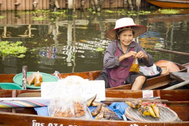 Amphawa, Tayland; 1 Ocak 2023: Amphawa ilçesinde yüzen bir pazarda kanolarında yiyecek satan kadınlar.