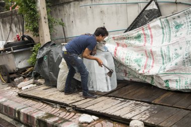 Bangkok, Tayland; 1 Ocak 2023: Bangkok sokaklarında buz kütlesi kıran bir adam.