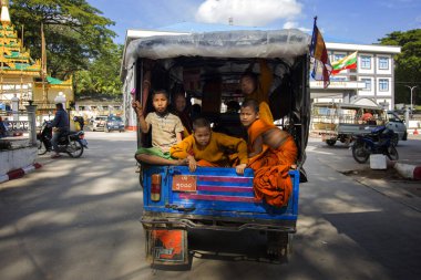 Burma, Myanmar; 1 Ocak 2023: Bir minibüsün arkasında oturan genç keşişler.