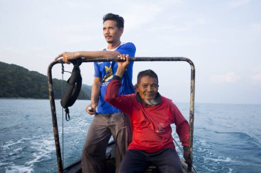 Koh Yao, Tayland; 1 Ocak 2023: Balıkçılar gün batımında Koh Yao limanında bir tekneden avlanıyorlar.