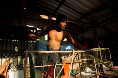 Koh Yao, Tayland; 1 Ocak 2023: Koh Yao balıkçı köyünde balık yakalamak için ağlar hazırlayan balıkçı.