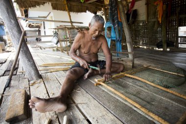 Koh Yao, Tayland; 1 Ocak 2023: Koh Yao balıkçı köyünde balık yakalamak için ağlar hazırlayan balıkçı.