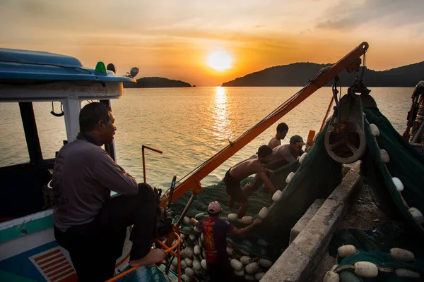 Koh Yao, Tayland; 1 Ocak 2023: Balıkçılar gün batımında Koh Yao limanında bir tekneden avlanıyorlar.