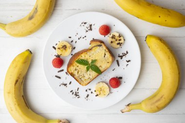 Muzlu kek ya da uzun bir kalıpla yapılmış ve kırmızı böğürtlenlerle süslenmiş muzlu ekmek..