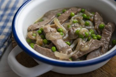 Biftek şeritleri soğan ve bezelye ile pişirilir..