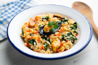 Midyeli İspanyol paella ve beyaz tabakta ıspanak..