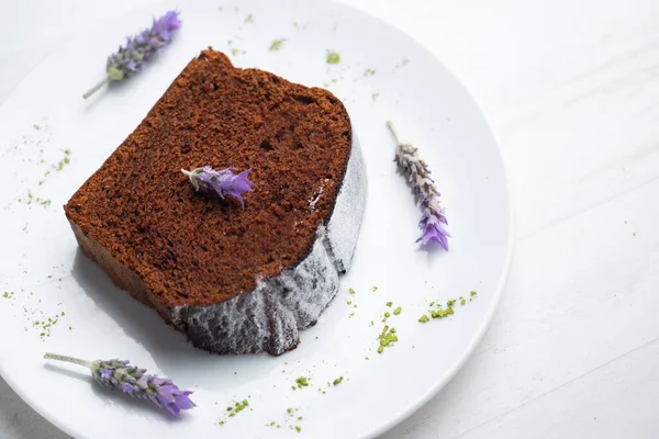 Chocolate cake with orange and some lavender flowers to decorate.