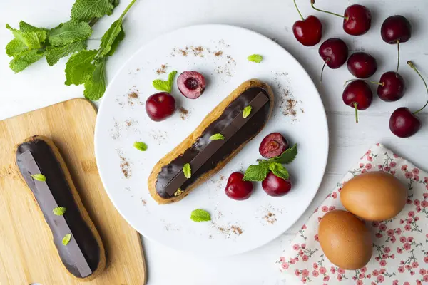 Eclares Franceses Cheios Creme Chocolate Servidos Com Cerejas Frescas — Fotografia de Stock