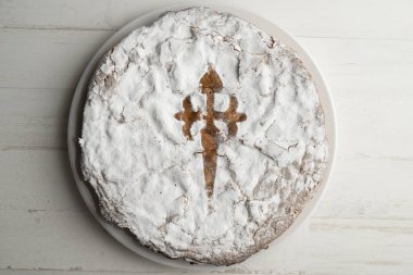 Tarta de Santiago, Galiçya mutfağının en tipik tatlısıdır ve merkezdeki sembolik Santiago Haçı ile kolayca tanınır..