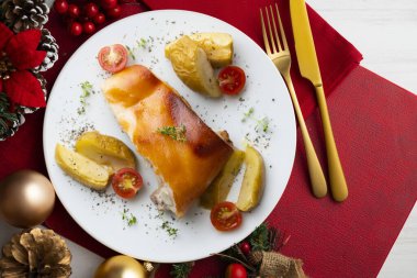 Segovia emziren domuzu elmayla fırında pişiriyor. Noel süsleriyle dolu bir masada servis edilmiş..