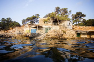 İspanya 'nın İbiza Adası' ndaki Sa Caleta plajındaki balıkçı evi..