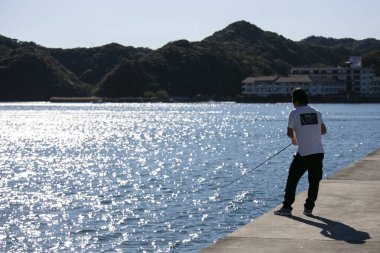 Nachikatsuura, Japonya; 1 Ekim 2023: Yerel halk güneşli bir günde Nachikatsuura Limanı 'nda balık tutuyor.